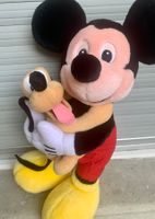 Peluche Mickey et Pluto dans ses bras